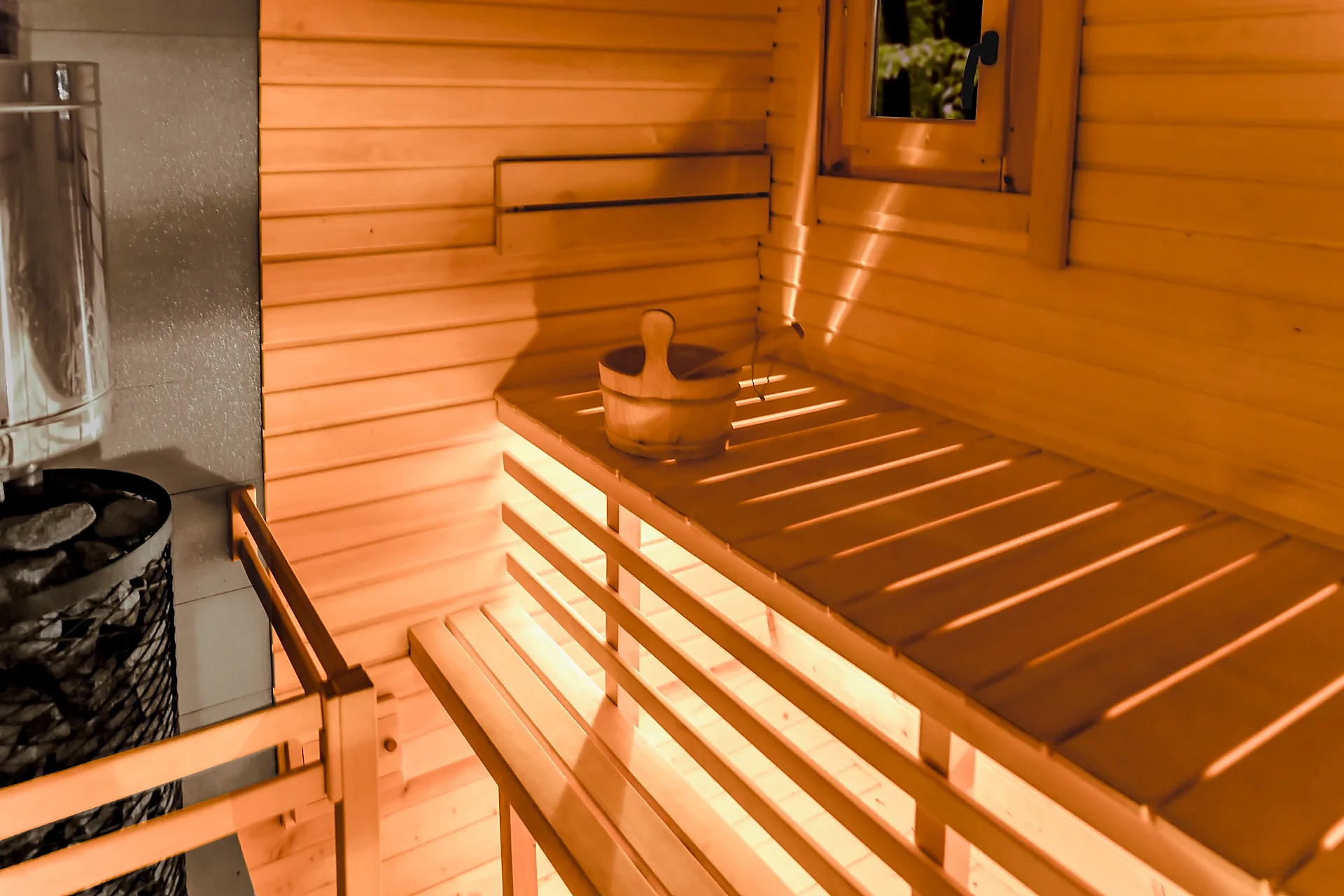 Holzofen und warme Holzbänke in der Sauna
